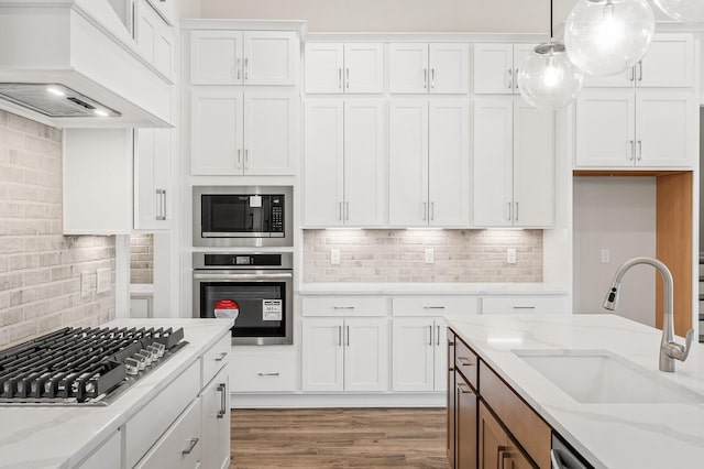 7503 Old Nashville Rd, Fairview, TN 37062 - kitchen featuring appliances with stainless steel finishes, custom range hood, decorative backsplash, white cabinets, and light stone countertops