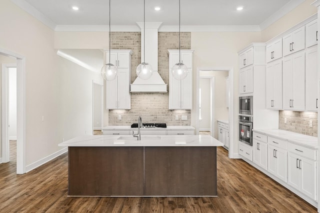 7503 Old Nashville Rd, Fairview, TN 37062 - kitchen with stainless steel appliances, decorative backsplash, white cabinets, ornamental molding, and an island with sink