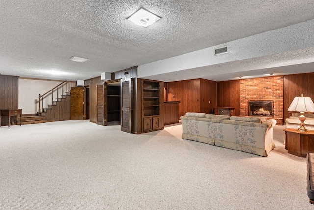 7125 Bidwell Rd, Joelton, TN 37080 - carpeted living area featuring wooden walls, a textured ceiling, stairway, and a brick fireplace