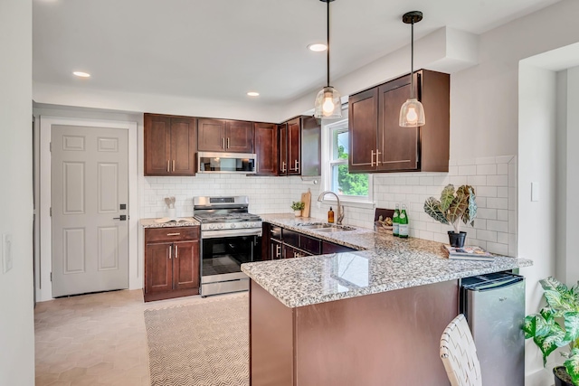 1192 Dalemere Dr, Nashville, TN 37207 - kitchen featuring stainless steel appliances, a sink, a peninsula, tasteful backsplash, and light stone countertops