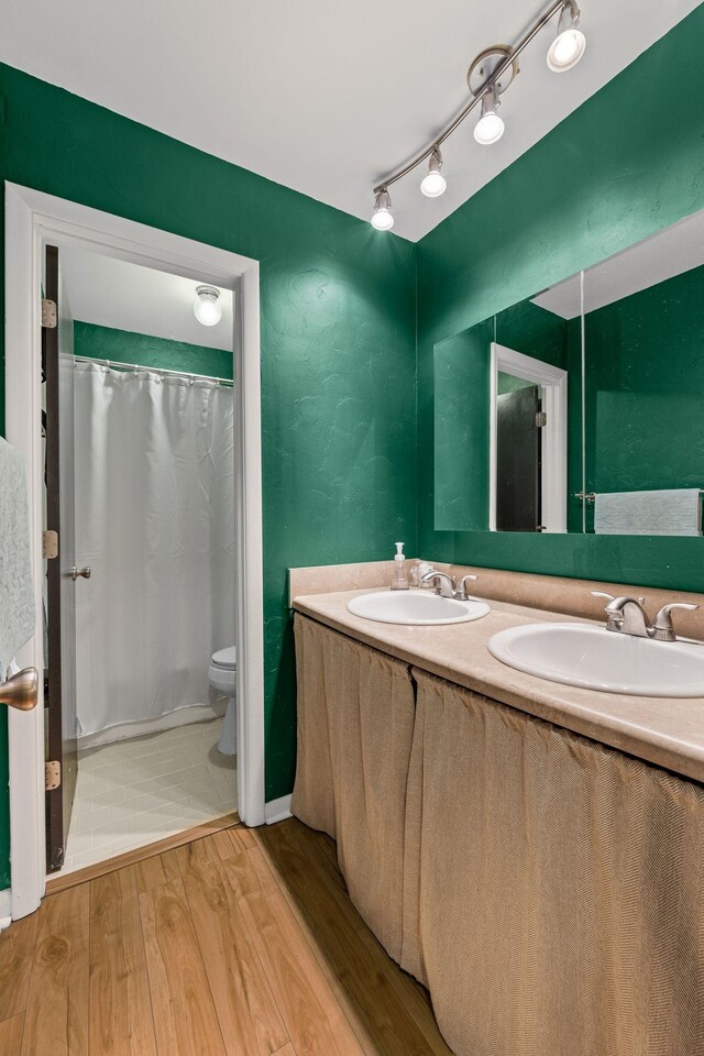 4425 Westlawn Dr Unit A301, Nashville, TN 37209 - bathroom featuring double vanity, toilet, wood finished floors, and a shower with shower curtain