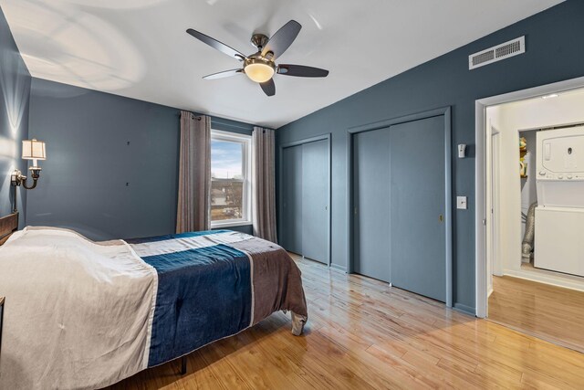 4425 Westlawn Dr Unit A301, Nashville, TN 37209 - bedroom featuring stacked washer / drying machine, multiple closets, light wood-style flooring, and a ceiling fan
