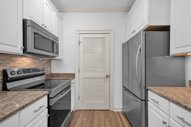 1010 16th Ave S Unit 301, Nashville, TN 37212 - kitchen featuring stainless steel appliances, light wood-style floors, backsplash, white cabinets, and crown molding