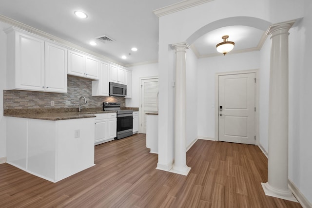 1010 16th Ave S Unit 301, Nashville, TN 37212 - kitchen featuring appliances with stainless steel finishes, decorative columns, white cabinets, tasteful backsplash, and crown molding