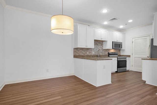 1010 16th Ave S Unit 301, Nashville, TN 37212 - kitchen with appliances with stainless steel finishes, crown molding, white cabinetry, wood finished floors, and tasteful backsplash
