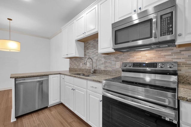 1010 16th Ave S Unit 301, Nashville, TN 37212 - kitchen featuring stainless steel appliances, a sink, white cabinetry, light wood-style floors, and ornamental molding