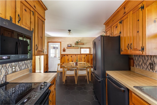 4600 Saunders Ave, Nashville, TN 37216 - kitchen with dishwashing machine, electric stove, black microwave, brown cabinetry, and wood walls