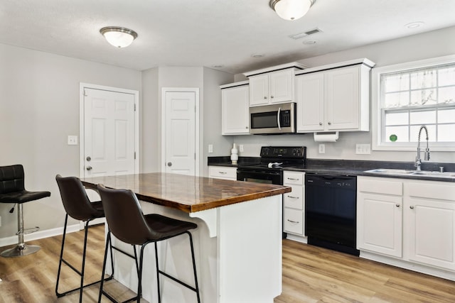 215 Azalea Dr, Oak Grove, KY 42262 - kitchen featuring black appliances, a sink, a kitchen breakfast bar, light wood-style floors, and white cabinets