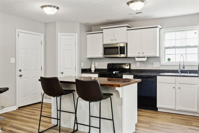 215 Azalea Dr, Oak Grove, KY 42262 - kitchen with black appliances, a sink, a kitchen bar, wooden counters, and white cabinetry