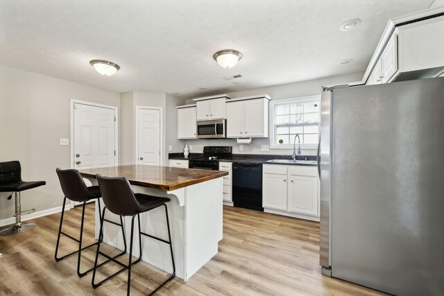 215 Azalea Dr, Oak Grove, KY 42262 - kitchen featuring black appliances, a sink, wooden counters, a kitchen breakfast bar, and white cabinets
