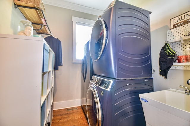 2914 Chasepointe Pl, Columbia, TN 38401 - washroom with stacked washing machine and dryer, crown molding, baseboards, and wood finished floors