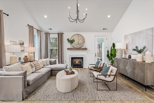 118 Portico Pl, La Vergne, TN 37086 - living room with lofted ceiling, wood finished floors, a chandelier, a high end fireplace, and recessed lighting
