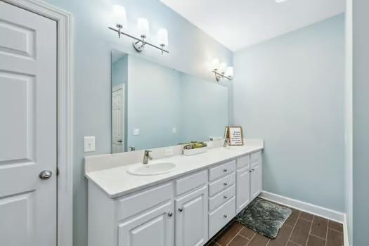 200 Heathstone Cir, Franklin, TN 37069 - bathroom featuring double vanity, baseboards, and wood finish floors