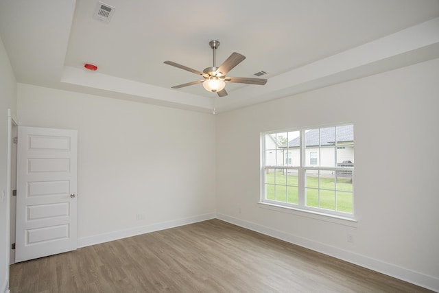 324 Fieldstone Ln, Springfield, TN 37172 - spare room featuring a tray ceiling, wood finished floors, a ceiling fan, and baseboards
