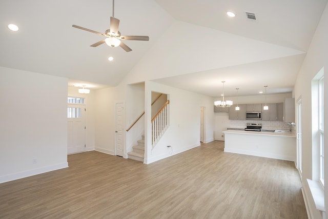324 Fieldstone Ln, Springfield, TN 37172 - unfurnished living room featuring high vaulted ceiling, stairway, light wood finished floors, recessed lighting, and a chandelier