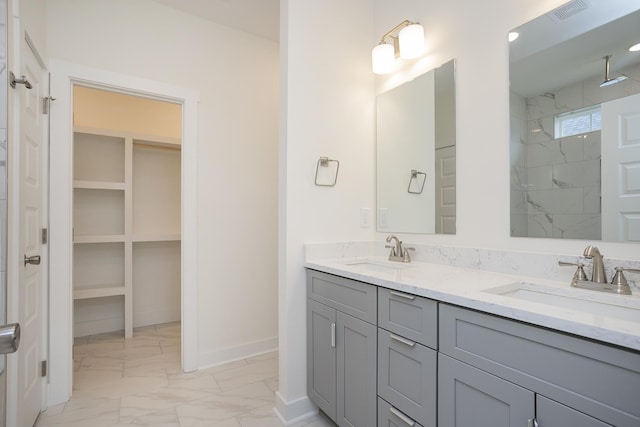 324 Fieldstone Ln, Springfield, TN 37172 - bathroom featuring marble finish flooring, double vanity, baseboards, a tile shower, and a walk in closet