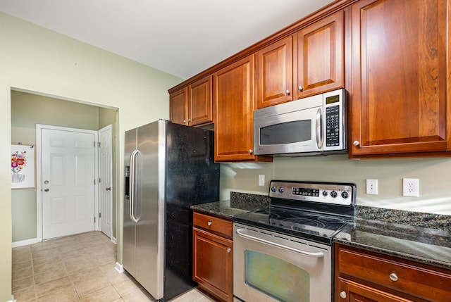 443 Lazy Creek Ln, Nashville, TN 37211 - kitchen featuring stainless steel appliances, dark stone countertops, light tile patterned floors, and baseboards