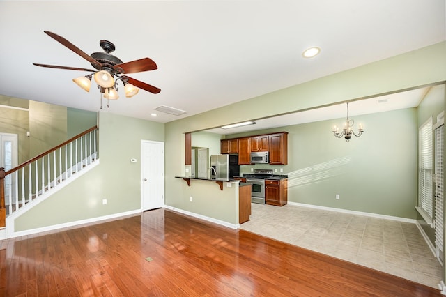 443 Lazy Creek Ln, Nashville, TN 37211 - kitchen featuring stainless steel appliances, dark countertops, a breakfast bar, light wood-type flooring, and a peninsula