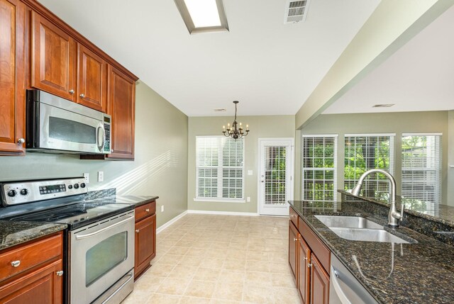 443 Lazy Creek Ln, Nashville, TN 37211 - kitchen featuring stainless steel appliances, a sink, baseboards, a chandelier, and dark stone countertops