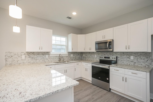 302 Fieldstone Ln, Springfield, TN 37172 - kitchen with appliances with stainless steel finishes, a sink, white cabinetry, light stone counters, and recessed lighting