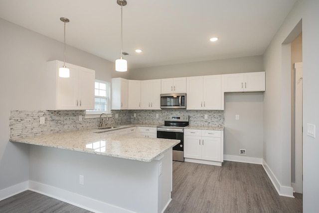 302 Fieldstone Ln, Springfield, TN 37172 - kitchen featuring appliances with stainless steel finishes, a peninsula, a sink, backsplash, and white cabinets