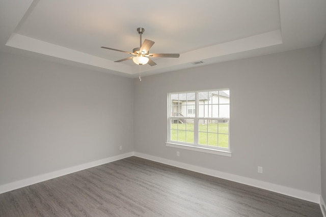 302 Fieldstone Ln, Springfield, TN 37172 - spare room with a tray ceiling, ceiling fan, dark wood-type flooring, and baseboards
