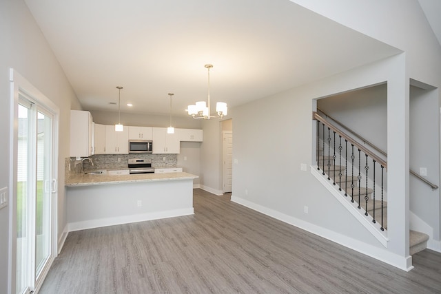 302 Fieldstone Ln, Springfield, TN 37172 - kitchen with stainless steel appliances, light wood-style floors, a sink, backsplash, and white cabinets