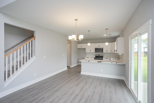 340 Fieldstone Ln, Springfield, TN 37172 - kitchen with appliances with stainless steel finishes, light wood-style flooring, backsplash, light countertops, and white cabinetry