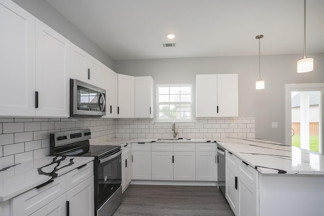 340 Fieldstone Ln, Springfield, TN 37172 - kitchen with stainless steel appliances, a sink, a peninsula, decorative backsplash, and white cabinetry