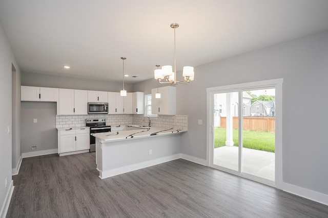 340 Fieldstone Ln, Springfield, TN 37172 - kitchen featuring appliances with stainless steel finishes, a sink, a peninsula, light countertops, and a chandelier
