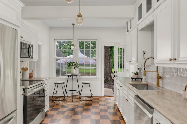 207 Cumberland Cir, Nashville, TN 37214 - kitchen featuring appliances with stainless steel finishes, a sink, white cabinetry, glass insert cabinets, and light stone countertops