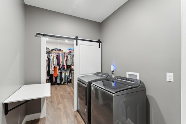 468 Olin Bean Rd, Red Boiling Springs, TN 37150 - laundry area featuring independent washer and dryer, light wood finished floors, and a barn door