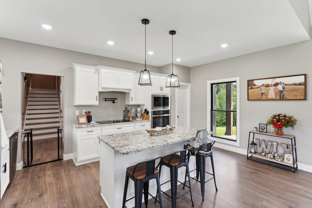 468 Olin Bean Rd, Red Boiling Springs, TN 37150 - kitchen featuring wall oven, stainless steel microwave, dark wood-type flooring, light stone countertops, and a breakfast bar
