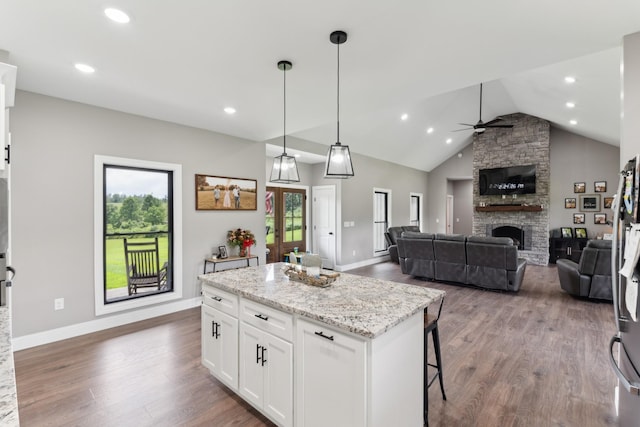 468 Olin Bean Rd, Red Boiling Springs, TN 37150 - kitchen featuring a stone fireplace, dark wood finished floors, a kitchen island, white cabinets, and lofted ceiling