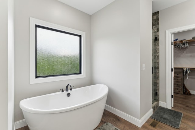 468 Olin Bean Rd, Red Boiling Springs, TN 37150 - full bath featuring a spacious closet, a shower stall, a freestanding bath, and wood finished floors