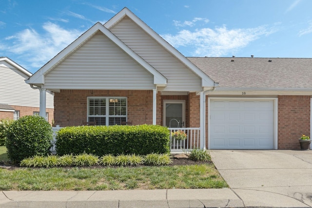 18 Holland Park Ln, Franklin, TN 37069 - view of front of home featuring brick siding, driveway, an attached garage, a porch, and roof with shingles