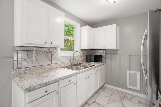 2607 Mashburn Ct, Nashville, TN 37210 - kitchen with freestanding refrigerator, a sink, light countertops, light marble finish floors, and white cabinets