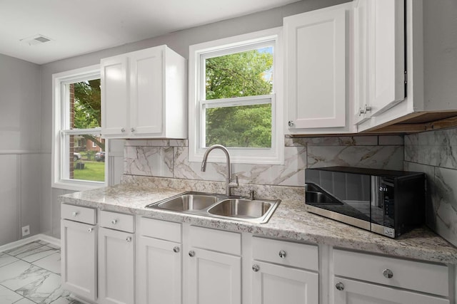 2607 Mashburn Ct, Nashville, TN 37210 - kitchen featuring a sink, stainless steel microwave, white cabinetry, and decorative backsplash
