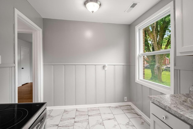2607 Mashburn Ct, Nashville, TN 37210 - unfurnished dining area featuring light marble finish floors, healthy amount of natural light, a decorative wall, and a wainscoted wall