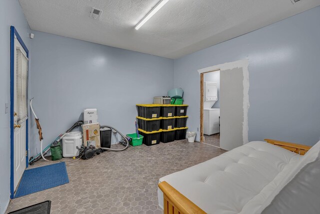 1049 E Trinity Ln, Nashville, TN 37216 - bedroom featuring stacked washer / drying machine and a textured ceiling