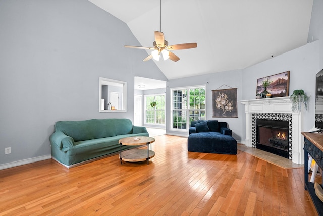 1052 Freedom Dr, Clarksville, TN 37042 - living area with ceiling fan, light wood-type flooring, a tile fireplace, high vaulted ceiling, and baseboards