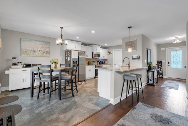 3555 Neena Ct, Clarksville, TN 37042 - kitchen with appliances with stainless steel finishes, a kitchen bar, a sink, baseboards, and recessed lighting