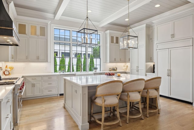 8118 Heirloom Blvd, College Grove, TN 37046 - kitchen with wall chimney exhaust hood, premium appliances, a chandelier, a kitchen island, and tasteful backsplash