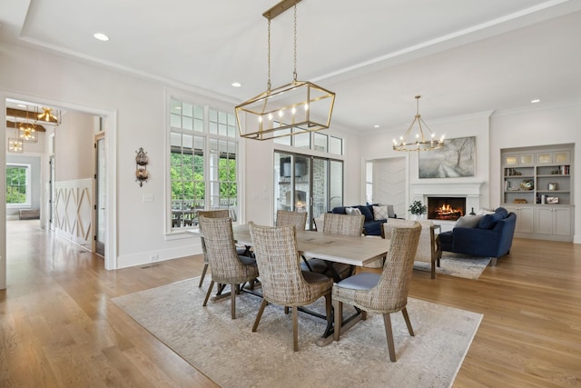 8118 Heirloom Blvd, College Grove, TN 37046 - dining area featuring a chandelier, healthy amount of natural light, a lit fireplace, crown molding, and recessed lighting