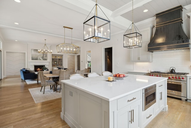 8118 Heirloom Blvd, College Grove, TN 37046 - kitchen with appliances with stainless steel finishes, premium range hood, a chandelier, a kitchen island, and tasteful backsplash