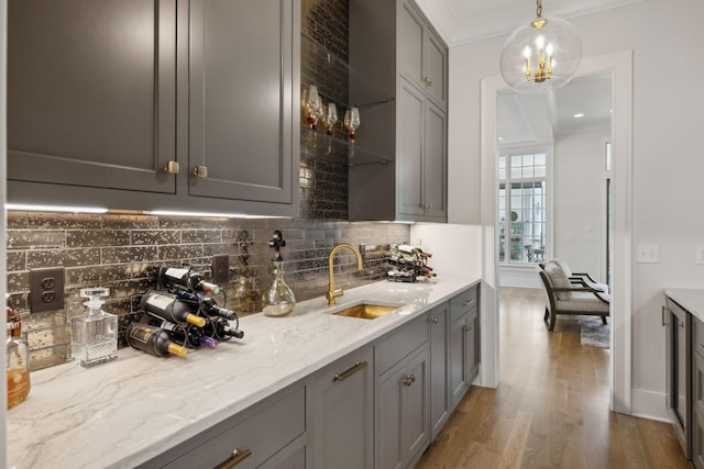 8118 Heirloom Blvd, College Grove, TN 37046 - kitchen featuring a sink, gray cabinetry, tasteful backsplash, wood finished floors, and light stone countertops