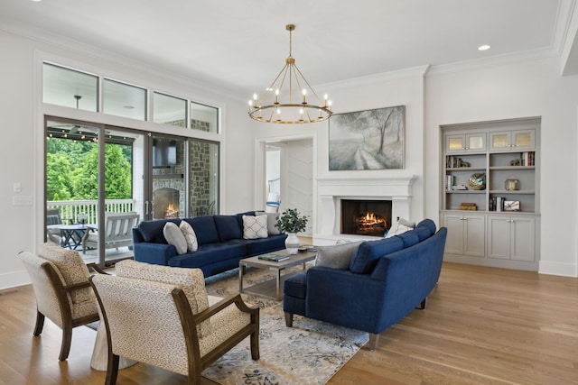 8118 Heirloom Blvd, College Grove, TN 37046 - living room featuring a lit fireplace, ornamental molding, light wood-type flooring, and a chandelier