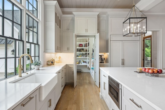 8118 Heirloom Blvd, College Grove, TN 37046 - kitchen featuring stainless steel microwave, a chandelier, light wood-style flooring, a sink, and healthy amount of natural light
