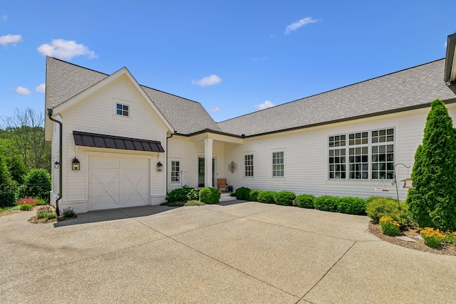 8118 Heirloom Blvd, College Grove, TN 37046 - modern farmhouse featuring concrete driveway, a standing seam roof, roof with shingles, a garage, and metal roof