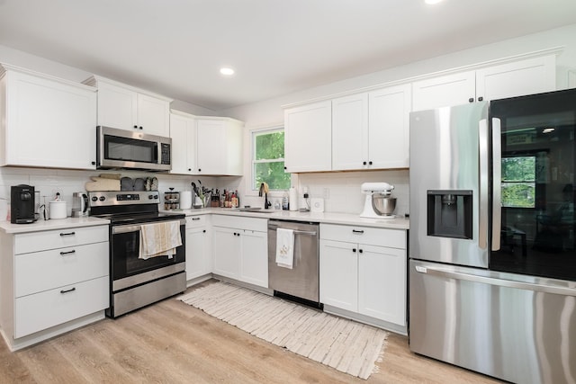 106 Aaron Dr, Burns, TN 37029 - kitchen with stainless steel appliances, a sink, light countertops, white cabinetry, and recessed lighting